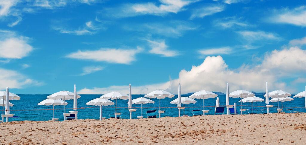 Ein Stand mit weißen Sonnenschirmen.