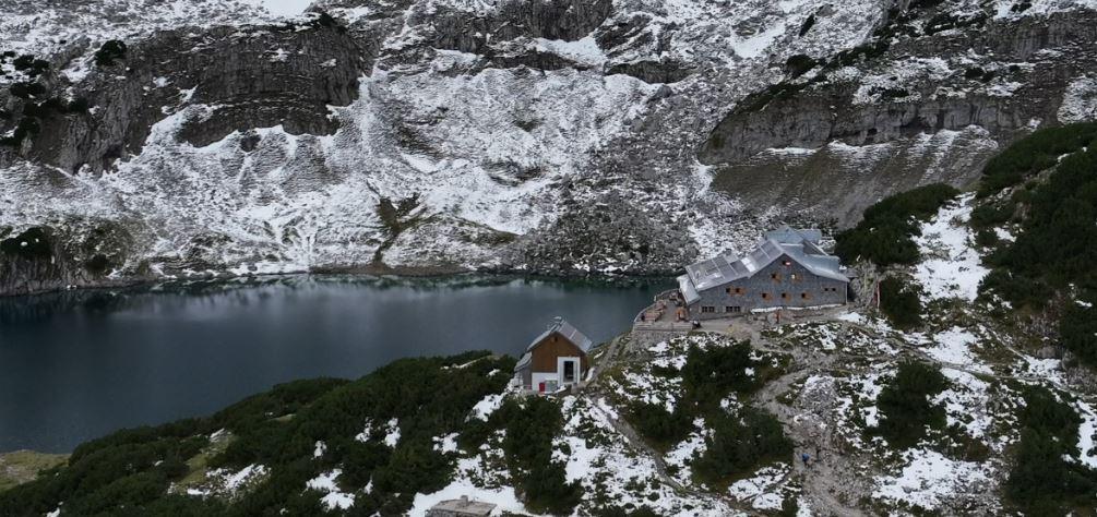 Die Coburger Hütte liegt inmitten halb verschneiter Felsen über dem Drachensee.