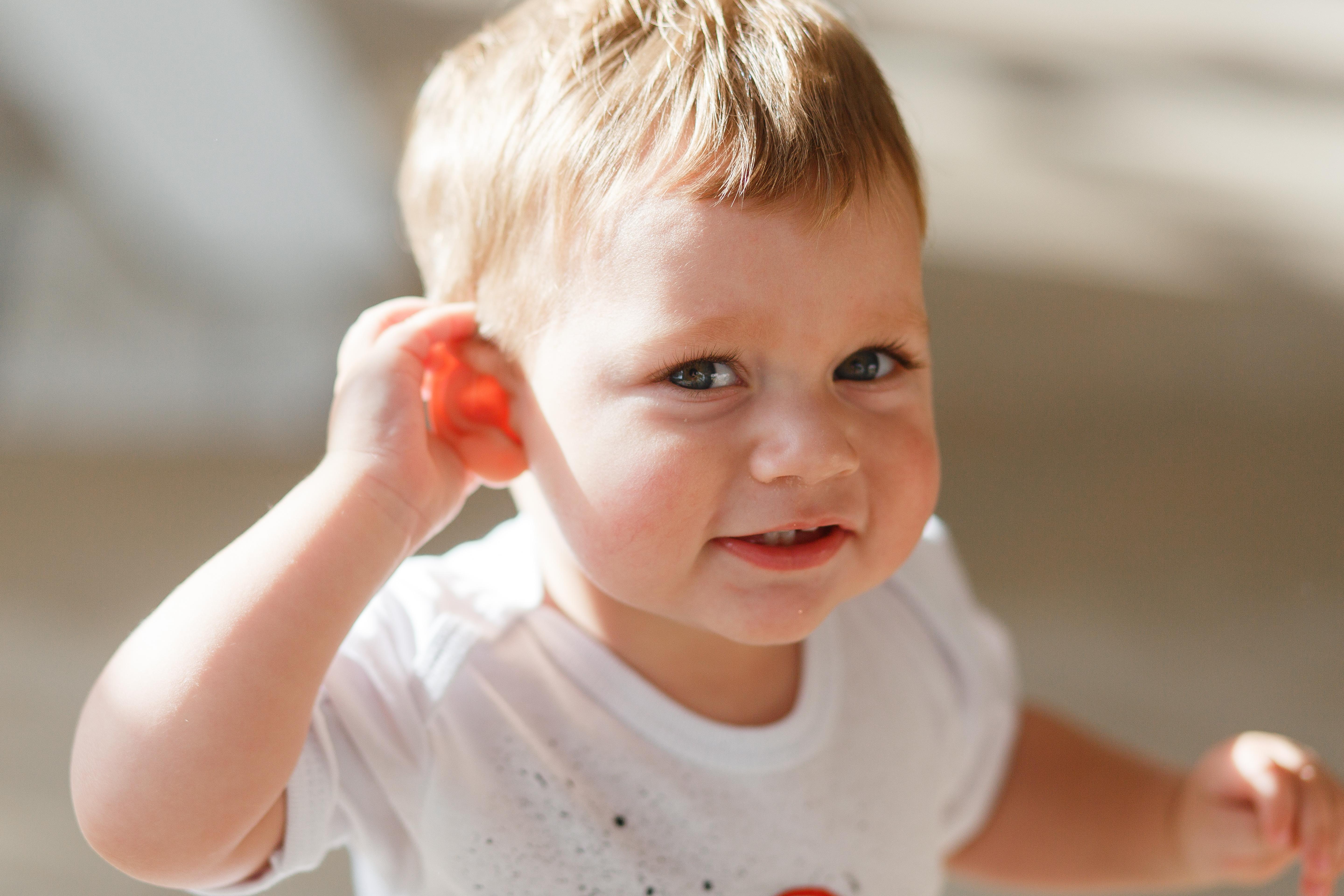 Hören dank Gentherapie: Neue Studien geben Kindern, die mit einer Mutation des OTOF-Gens zur Welt kommen und deshalb schlecht oder gar nicht hören, Hoffnung. Im Bild: Kleinkind mit Hand am Ohr.