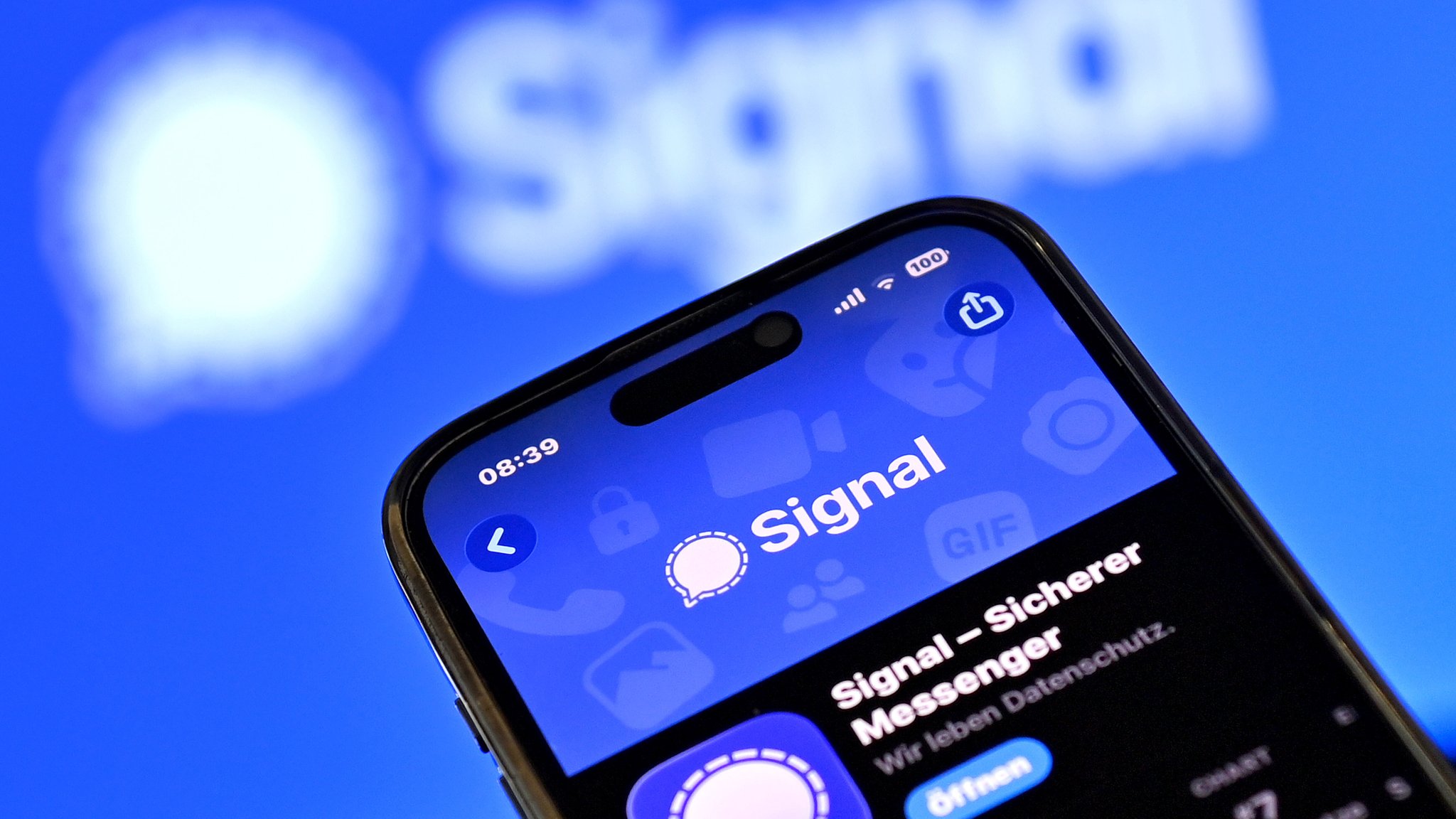 Handy mit Signal-App und Firmen-Logo im Hintergrund | Bild: picture alliance / SvenSimon Handy mit Signal-App und Firmen-Logo im Hintergrund