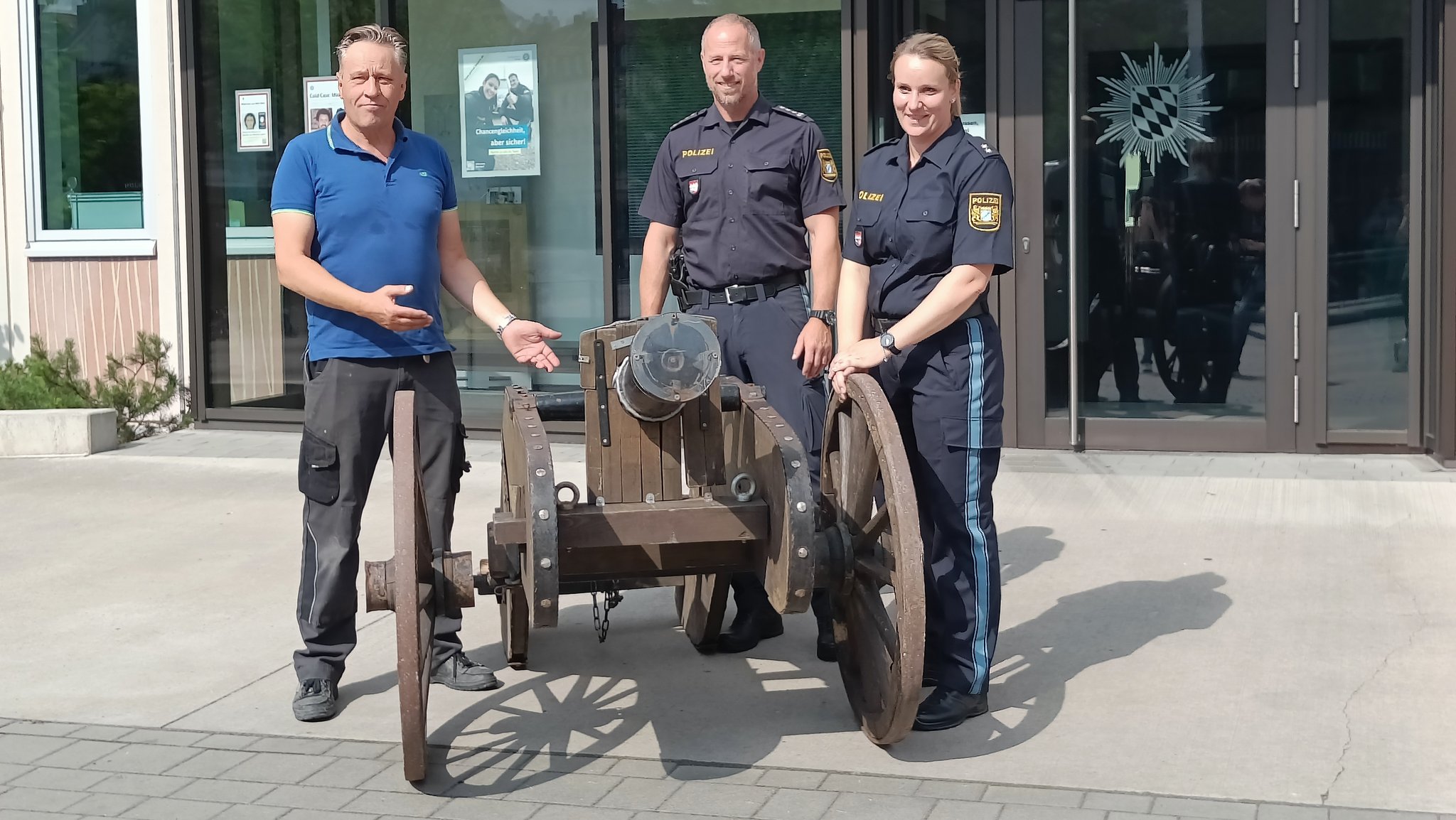 Schausteller August Schneider mit Polizeibeamten neben Deko-Kanone.