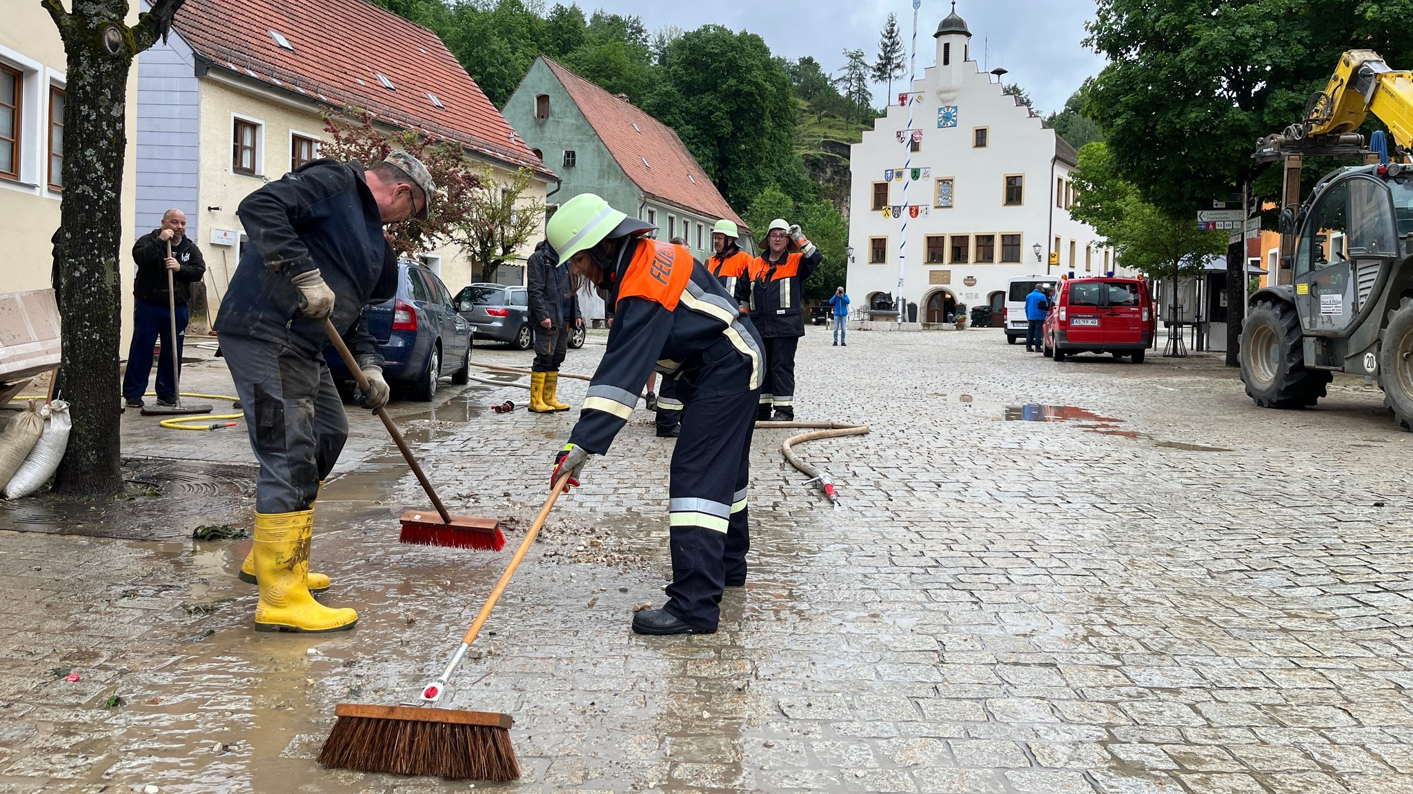 Feuerwehrleute und Anwohner reinigen die Straßen und Plätze am Tag danach