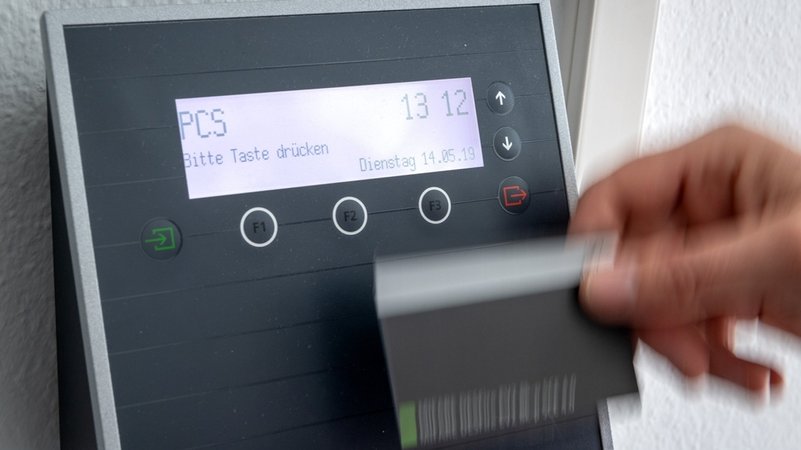 Ein Mitarbeiter erfasst seine Arbeitszeit digital an einem Terminal. | Bild: dpa-Bildfunk/Sina Schuldt Ein Mitarbeiter erfasst seine Arbeitszeit digital an einem Terminal.