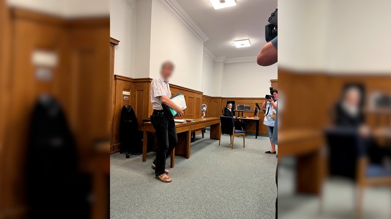 Ein Mann steht in einem Gerichtssaal.