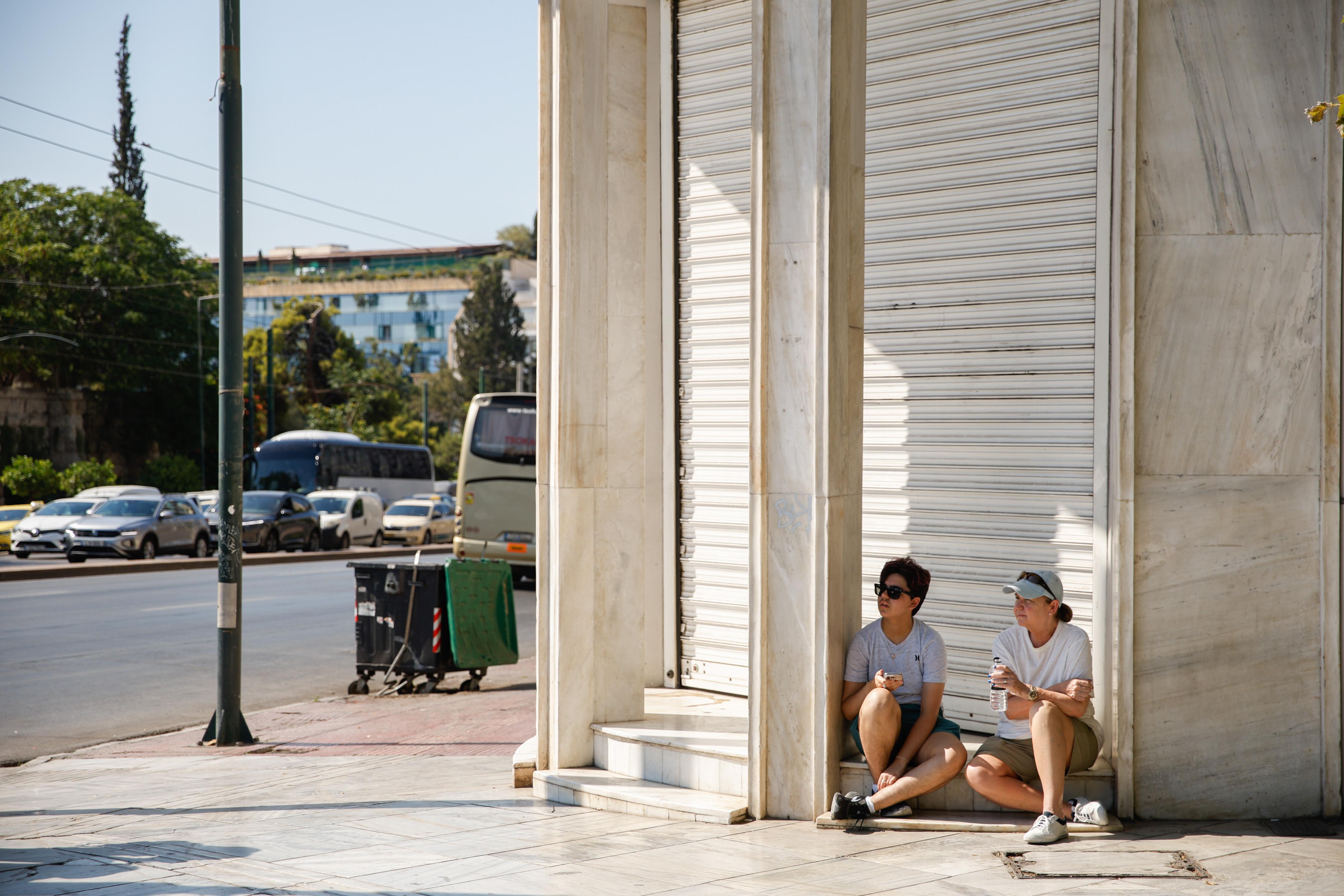 Touristen suchen im über 40 Grad heißen Athen Schutz im Schatten. 