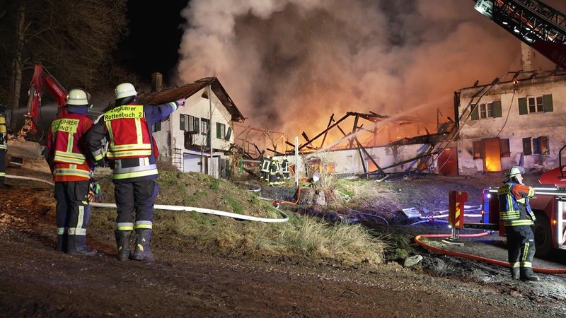 Feuerwehrleute löschen das brennende Bauernhaus.