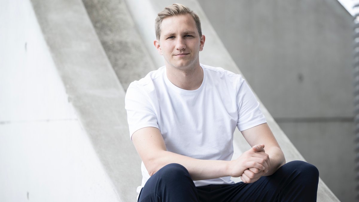 Ein junger Mann mit weißem T-Shirt schaut in die Kamera, es ist Sozialforscher Kilian Hampel
