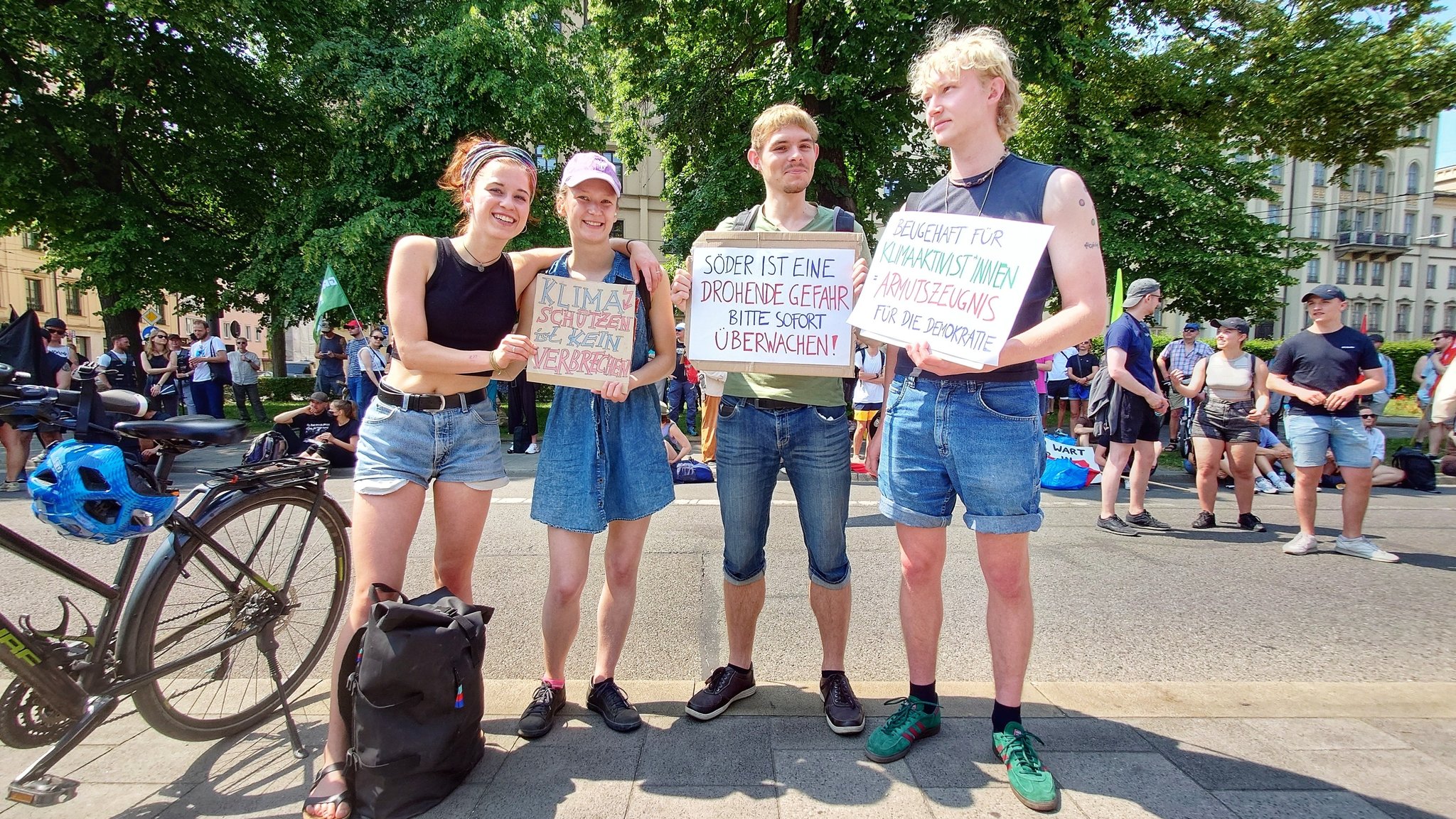 Demonstrierende halten Schilder gegen das Polizeiaufgabengesetz, (18.6.2023, München).