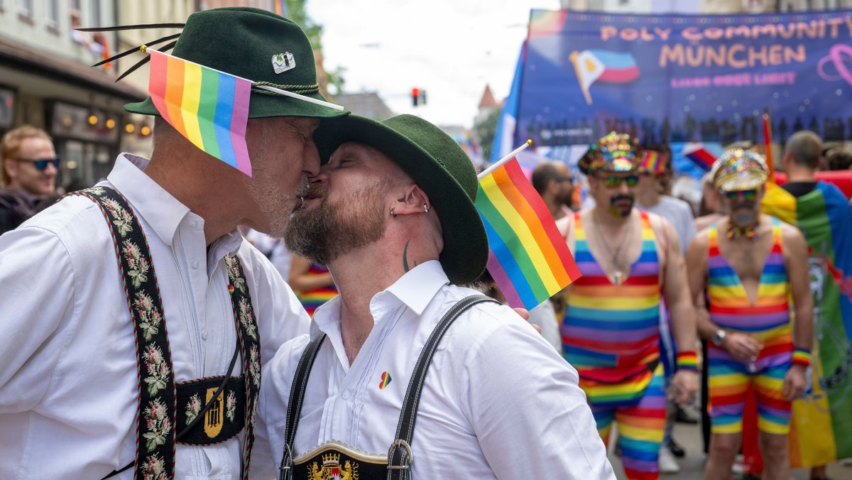 Beim Christopher Street Day küssen sich zwei Trachtler.