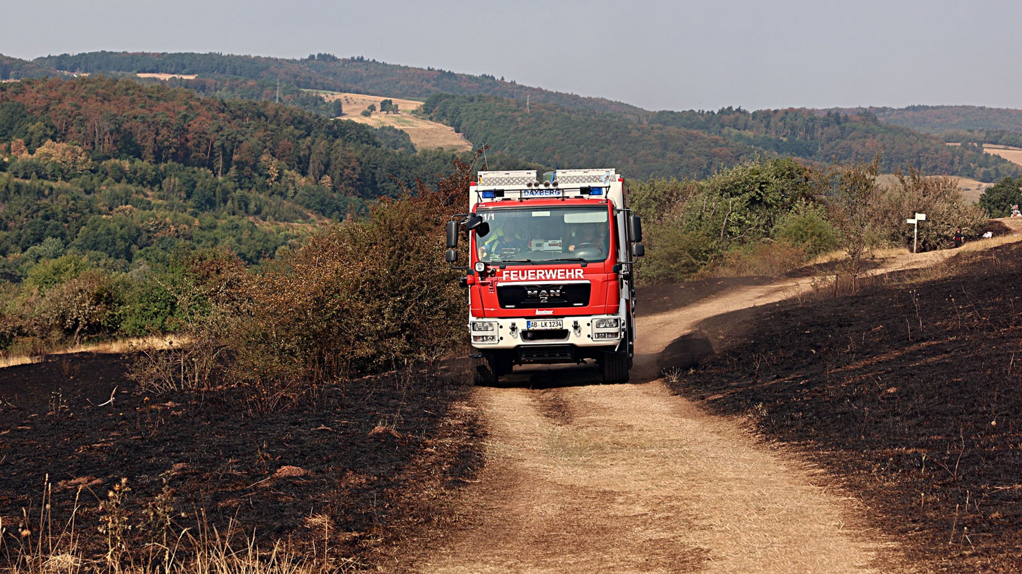 Feuerwehrauto fährt durch einen abgebrannten Bereich im Wald | Bild: Ralf Hettler Feuerwehrauto fährt durch einen abgebrannten Bereich im Wald