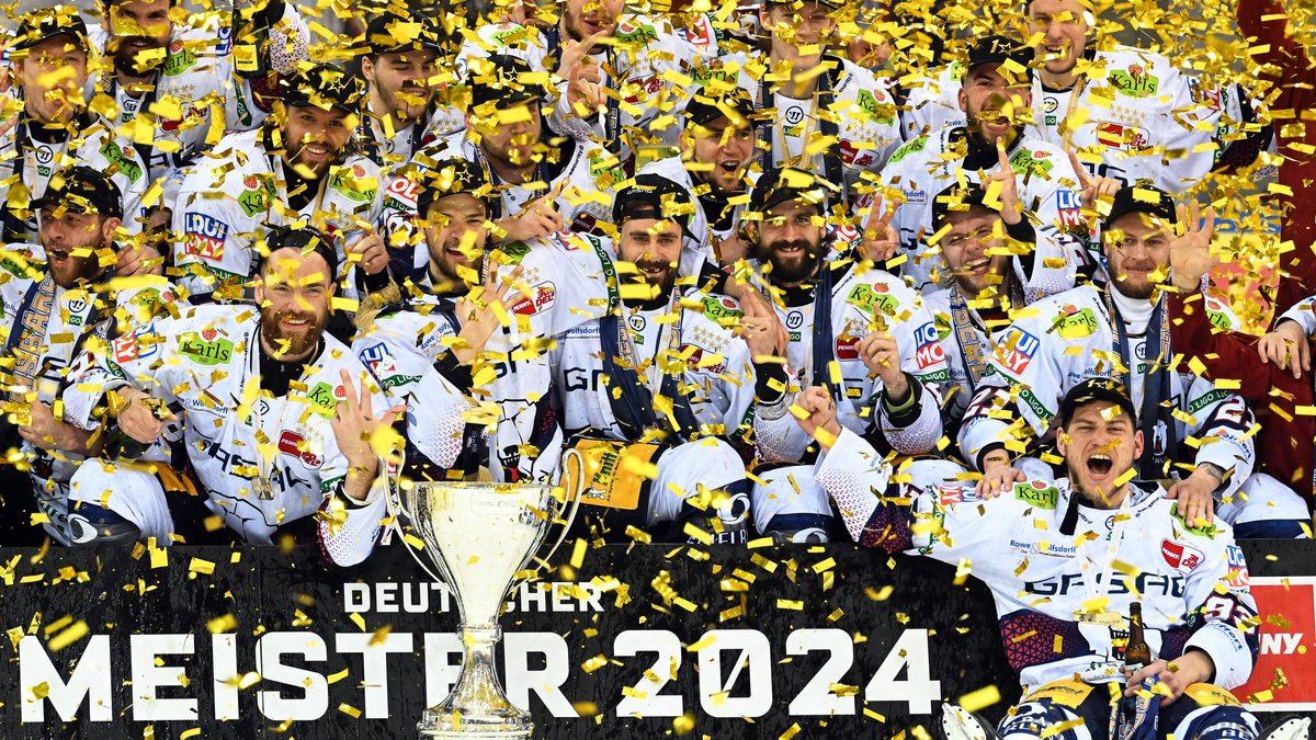 Berlins Spieler jubeln nach dem 2:0-Sieg mit dem Pokal über die zehnte deutsche Eishockey-Meisterschaft.