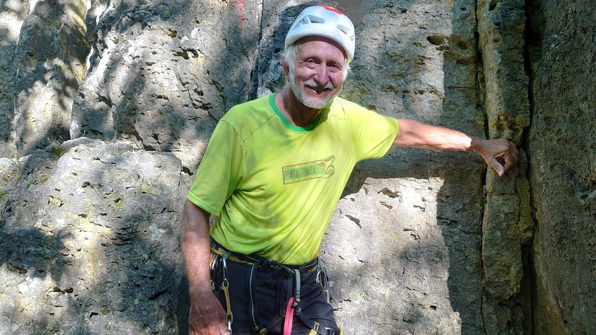 Immo Engelhard steht mit Klettergurt und Helm vor dem Röthelfels.