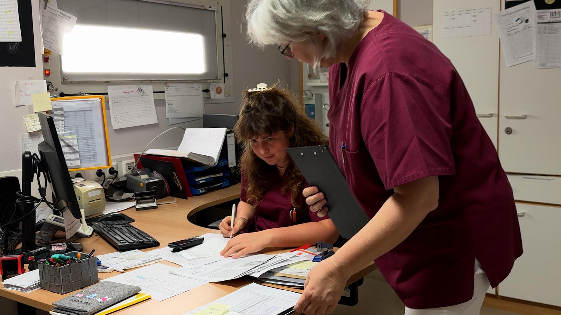 Hebammen im Kreißsaal Weißenburg sitzen über Abrechnungstabellen. Hebamme Katharina Spieler hat gekündigt, weil ihr Einkommen drastisch sinkt.