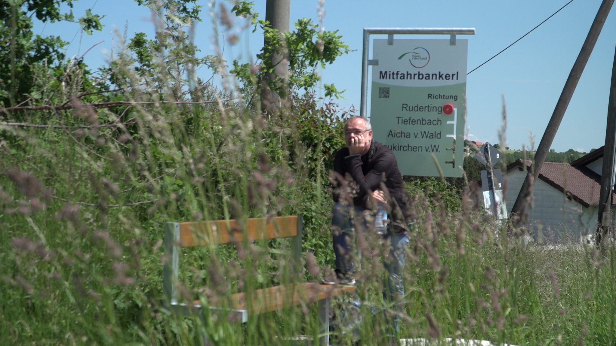 BR-Reporter Martin Gruber wartet am "Mitfahrbankerl"