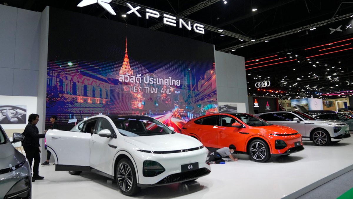 Besucher betrachten die Elektrofahrzeuge am Messestand des chinesischer Elektrofahrzeugherstellers "XPENG" während der 45. Bangkok Motor Show. 
