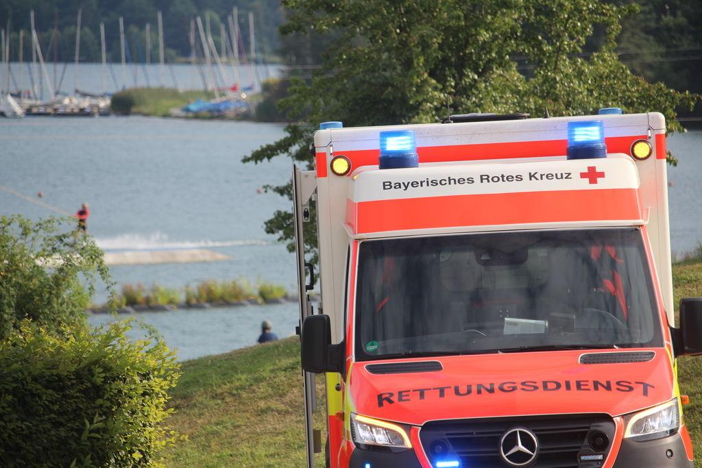 (Symbolbild) Ein Krankenwagen steht an einem Badesee.