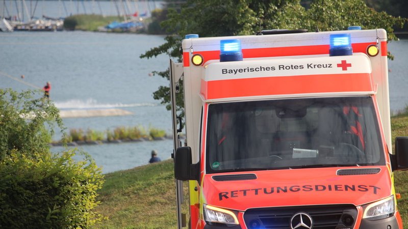 (Symbolbild) Ein Krankenwagen steht an einem Badesee. | Bild: BR/Marcel Kehrer (Symbolbild) Ein Krankenwagen steht an einem Badesee.