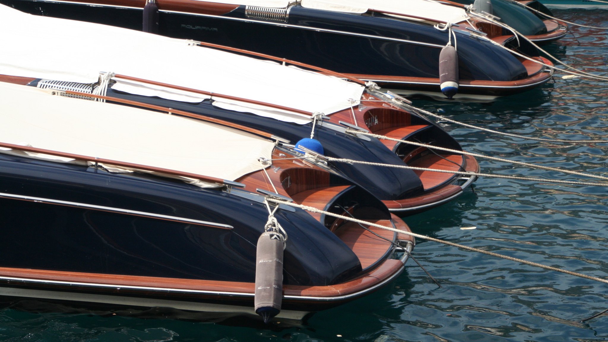 Mehrere Boote der Marke Riva Aquarama liegen an einem Steg.