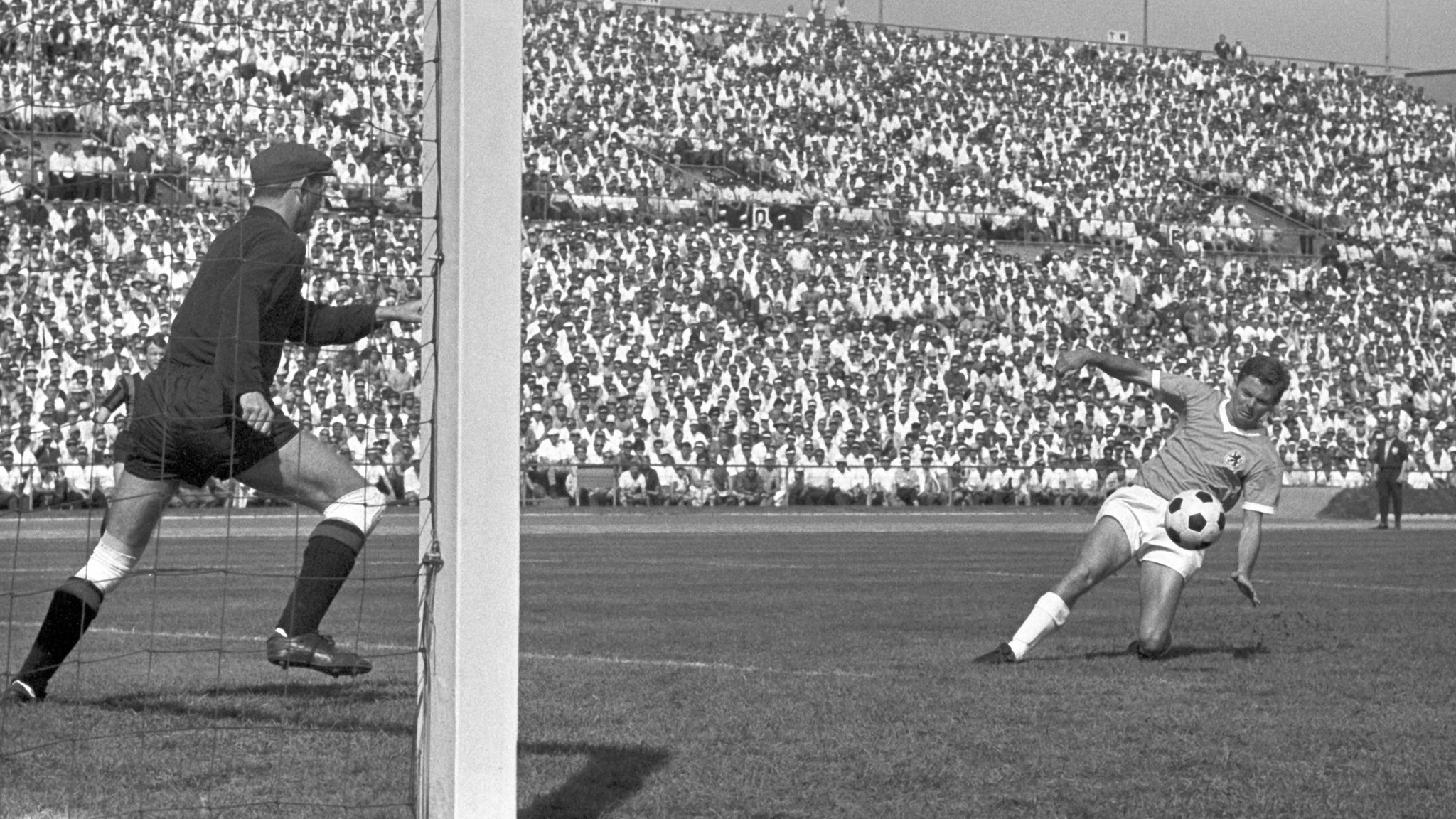 Momente vor dem 2:0 - Der TSV-1860-Spieler Wilfried Kohlars (R) taucht vor dem Tor von Eintrachts Schlussmann Egon Loy auf.