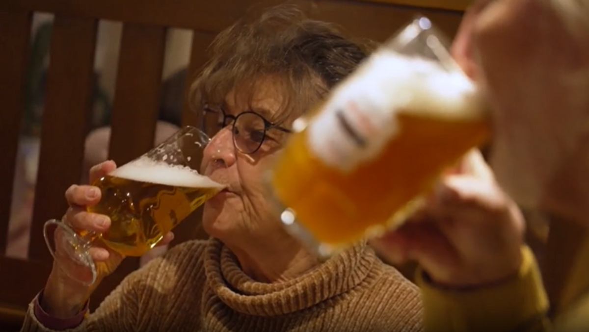 Zwei Menschen trinken in einer Gastwirtschaft aus Biergläsern alkoholfreies Bier.