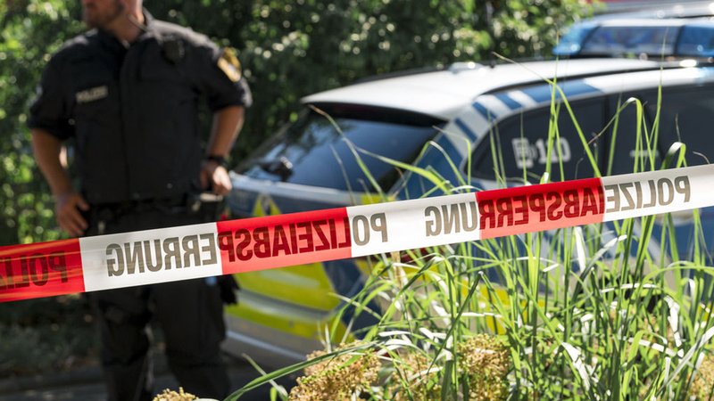 01.07.2025, Bayern, Mellrichstadt: Ein Polizist steht neben einem Polizeiauto. Ein 21-Jähriger hat in einer Firma in Unterfranken eine Kollegin getötet und zwei Männer schwer verletzt. Foto: Daniel Vogl/dpa +++ dpa-Bildfunk +++ | Bild: dpa-Bildfunk/Daniel Vogl 01.07.2025, Bayern, Mellrichstadt: Ein Polizist steht neben einem Polizeiauto. Ein 21-Jähriger hat in einer Firma in Unterfranken eine Kollegin getötet und zwei Männer schwer verletzt. Foto: Daniel Vogl/dpa +++ dpa-Bildfunk +++