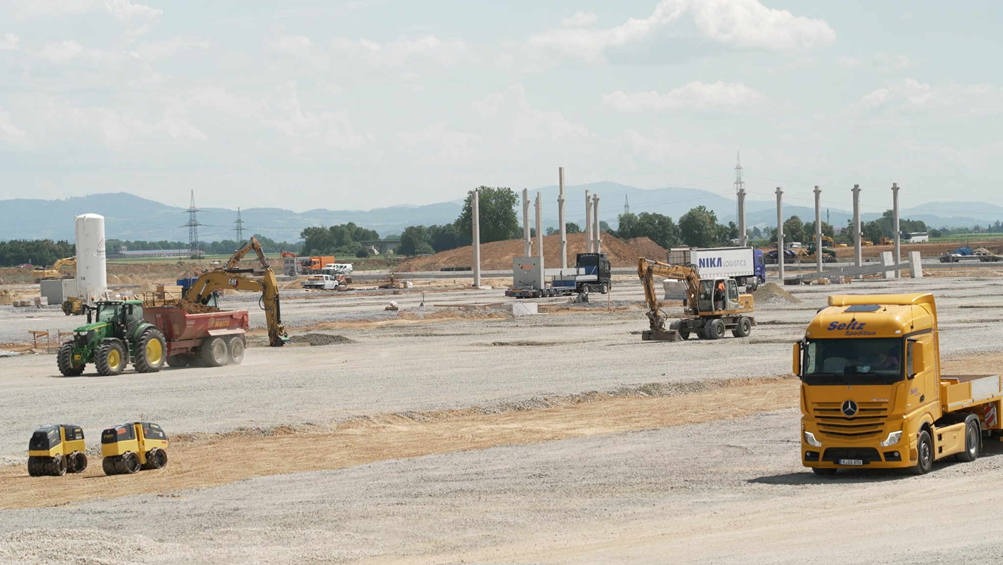 Schwere Baufahrzeuge rollen über die BMW-Baustelle bei Straßkirchen.