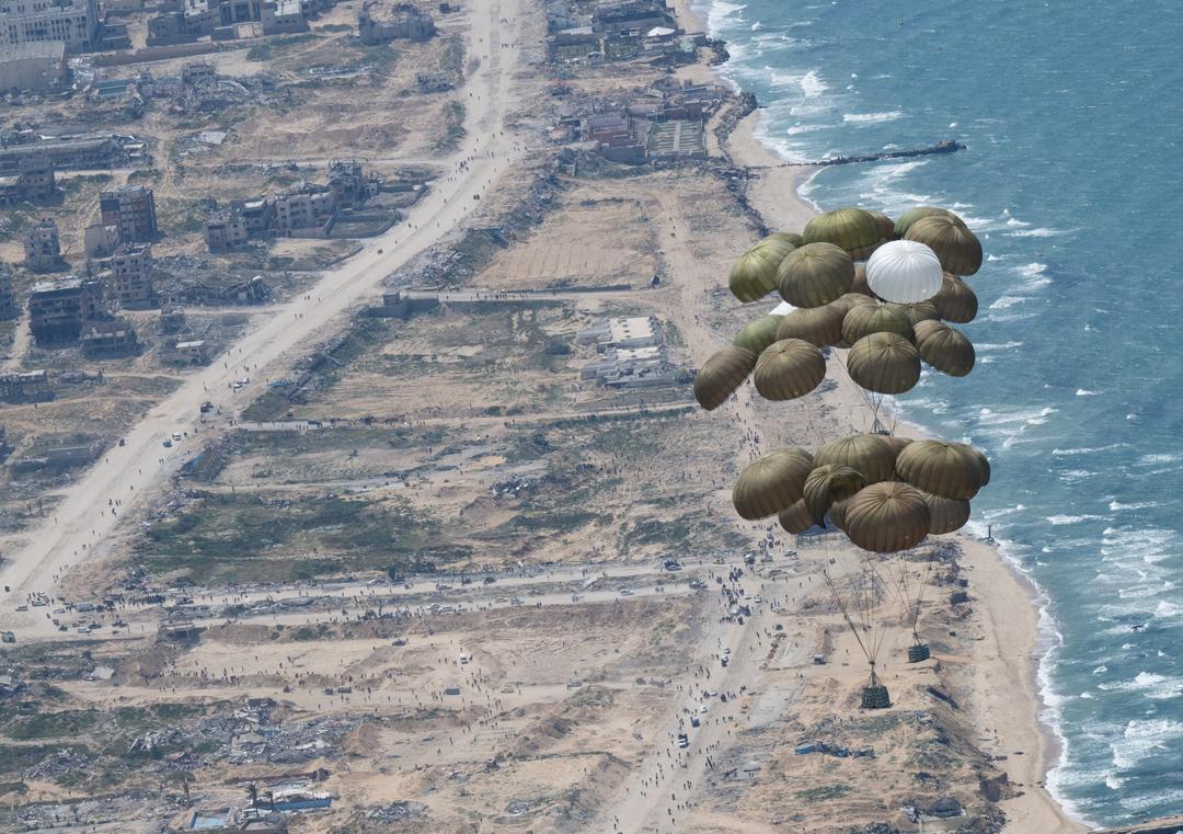Fallschirme mit Lebensmitteln schweben nach dem Abwurf aus einer Transportmaschine der Luftwaffe über dem Gazastreifen.