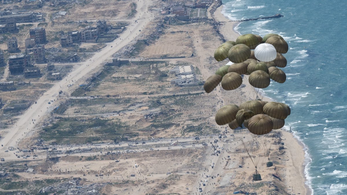 Fallschirme mit Lebensmitteln schweben nach dem Abwurf aus einer Transportmaschine der Luftwaffe über dem Gazastreifen.