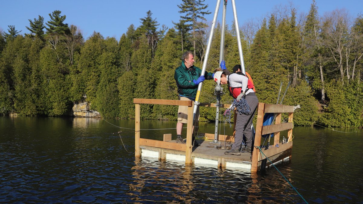 Die Wissenschaftler Tim Patterson (l), Carling Walsh und Zack Milani (hinten) bereiten sich auf die Entnahme der Sedimentprobe vom Grund des Crawford Lakes vor.