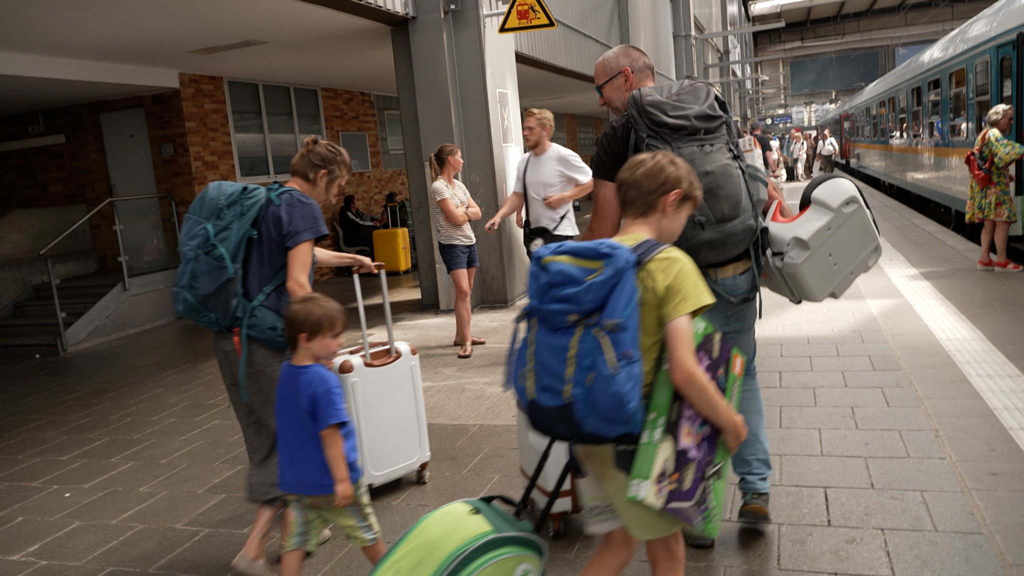 Familie mit Koffern auf einem Bahnsteig