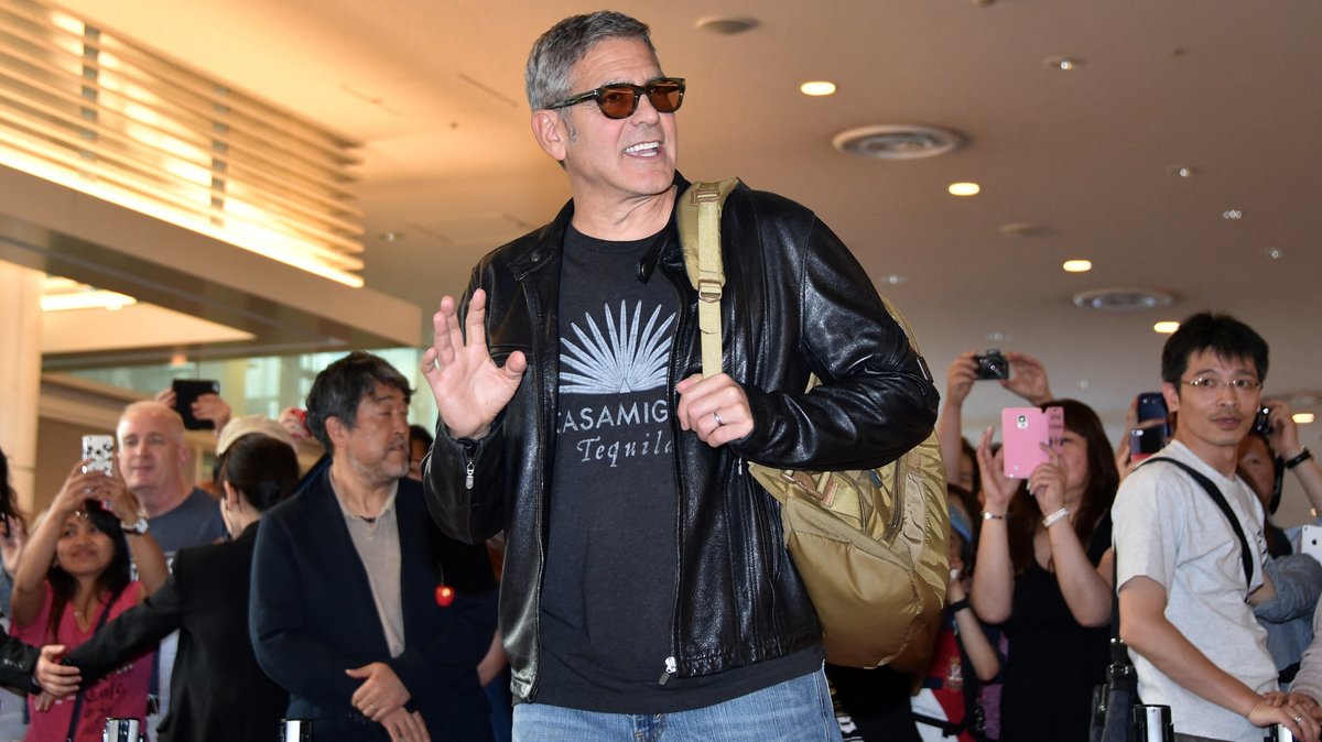 George Clooney vor fotografierenden Menschen.