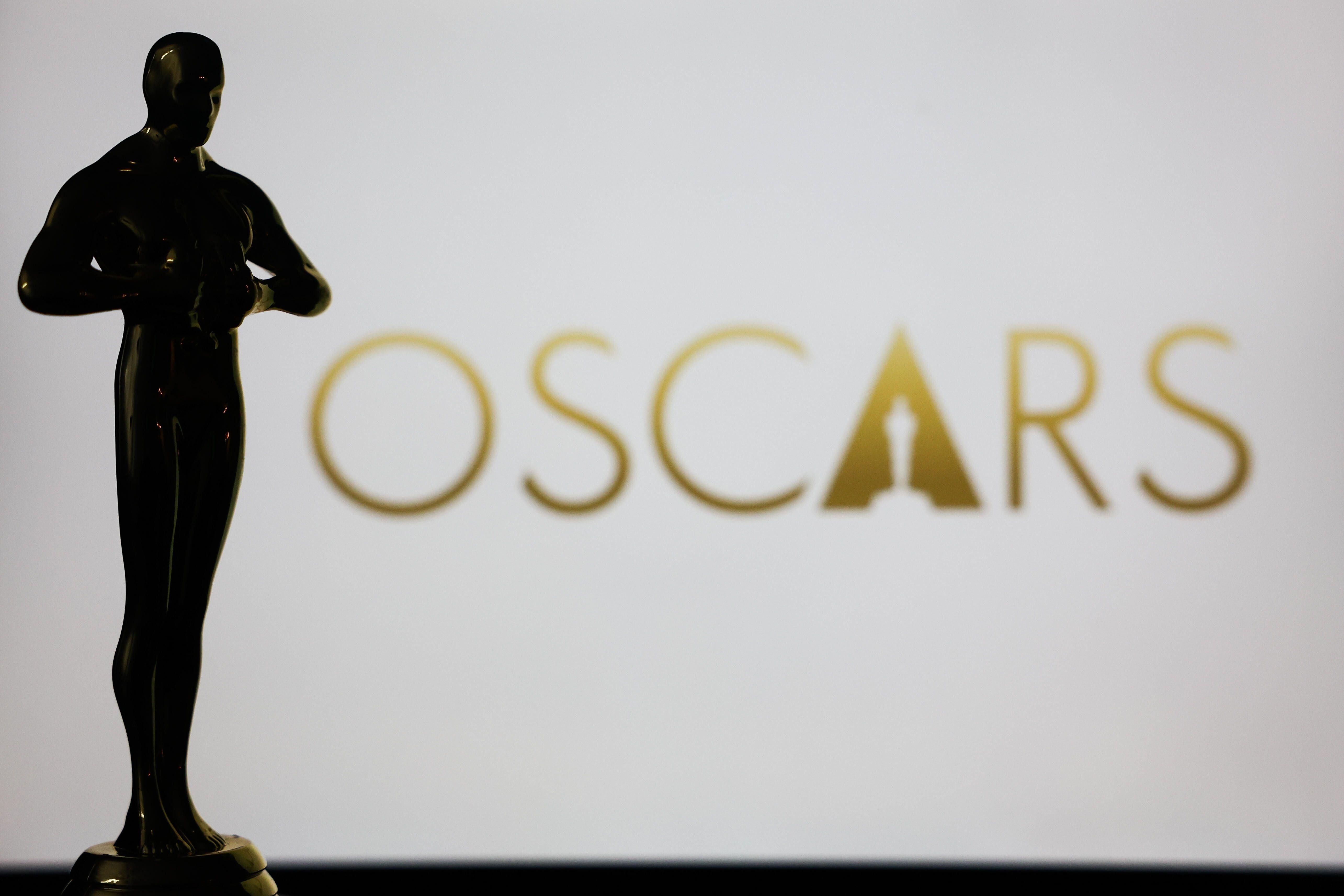 Zu sehen ist das goldene Oscars-Logo und eine Oscar-Statue im Vordergrund.