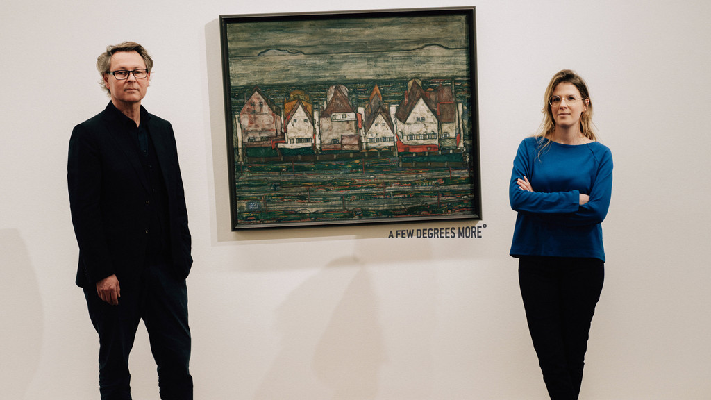 Hans-Peter Wipplinger, Direktor des Leopold Museums, und Claudia Michl, Leiterin des österreichischen Klimaforschungsnetzwerks CCCA, stehen neben dem Gemälde "Häuser am Meer" (1914) von Egon Schiele.