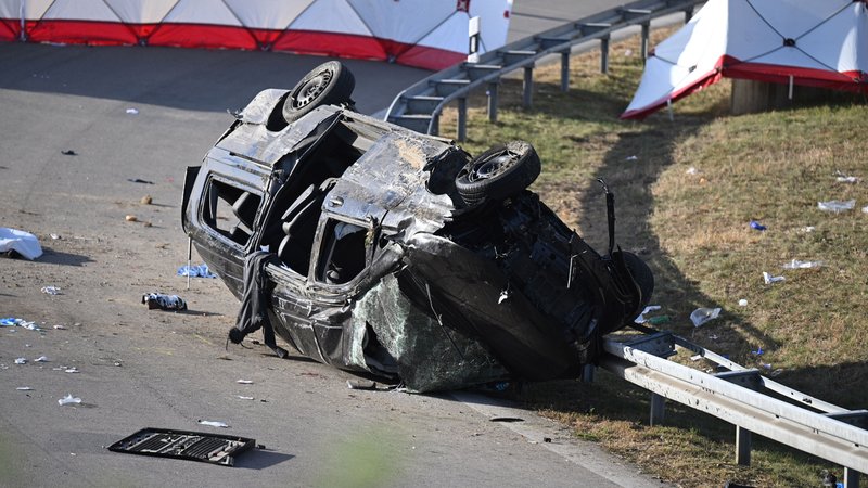Betreuer der Polizei stehen am Rande des umgestürzten Fahrzeugs. Beim Unfall eines mutmaßlichen Schleuserfahrzeugs auf der Autobahn 94 sind sieben Menschen gestorben und mehrere schwer verletzt worden. Der mit mehr als 20 Personen völlig überfüllte Transporter war beim Versuch, einer Polizeikontrolle davonzufahren, von der Straße abgekommen . | Bild: picture alliance/dpa | Sven Hoppe Betreuer der Polizei stehen am Rande des umgestürzten Fahrzeugs. Beim Unfall eines mutmaßlichen Schleuserfahrzeugs auf der Autobahn 94 sind sieben Menschen gestorben und mehrere schwer verletzt worden. Der mit mehr als 20 Personen völlig überfüllte Transporter war beim Versuch, einer Polizeikontrolle davonzufahren, von der Straße abgekommen .