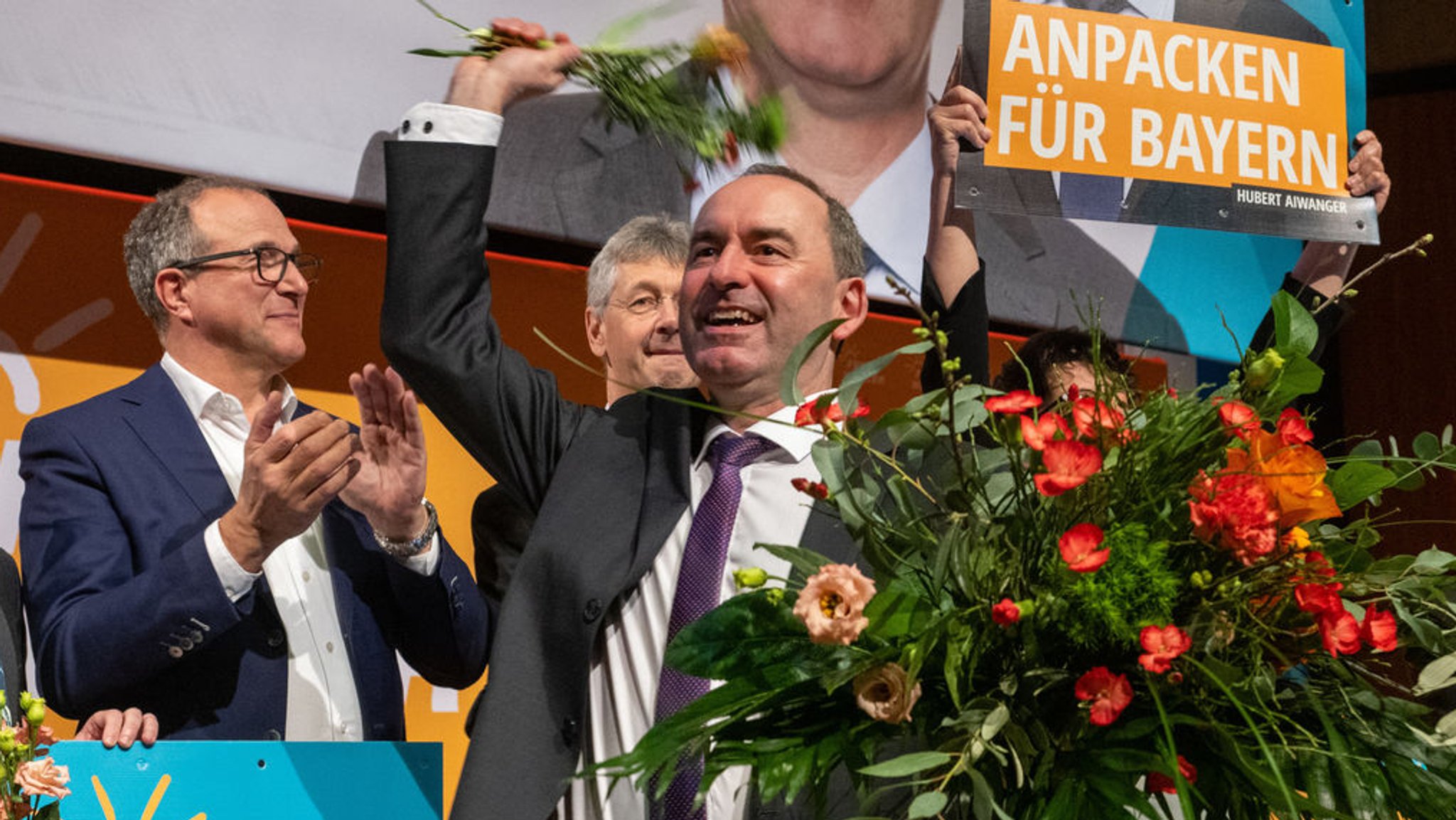 25.03.2023, Bayern, Augsburg: Hubert Aiwanger (Freie Wähler,r), Wirtschaftsminister von Bayern, wirft bei der Landesmitgliederversammlung und dem Programmparteitag der Freien Wähler im Kongress am Park nach seiner Wahl zum Spitzenkandidaten Blumen von der Bühne. Unter anderem geht es um die Wahl von Parteichef Hubert Aiwanger zum Spitzenkandidaten zur Landtagswahl und den Beschluss des Wahlprogramms. Foto: Stefan Puchner/dpa +++ dpa-Bildfunk +++