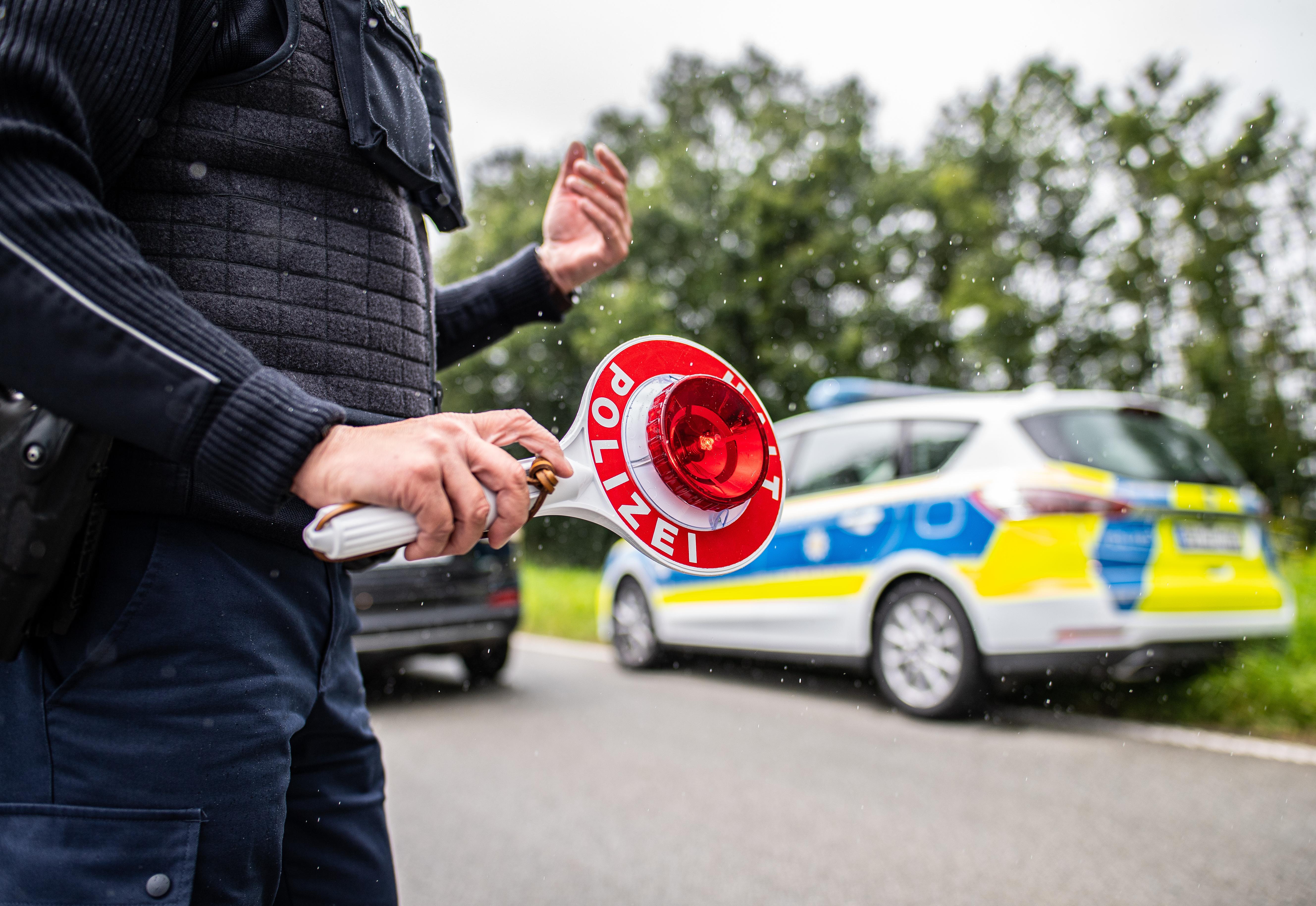 Eine Polizeibeamtin steht bei einer Corona-Einreisekontrolle der Bundespolizei an der Grenze und kontrolliert Fahrzeuge im Grenzgebiet.  | Bild:picture alliance/dpa | Guido Kirchner