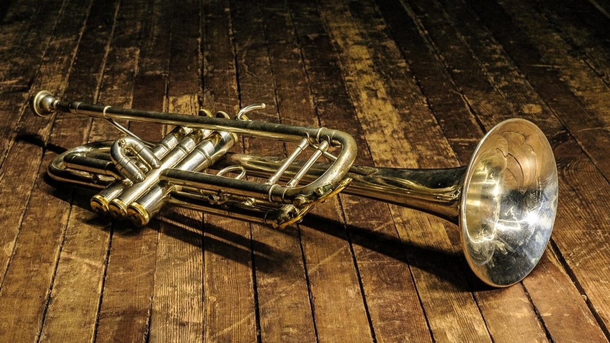 Eine Trompete liegt auf einem Holzboden