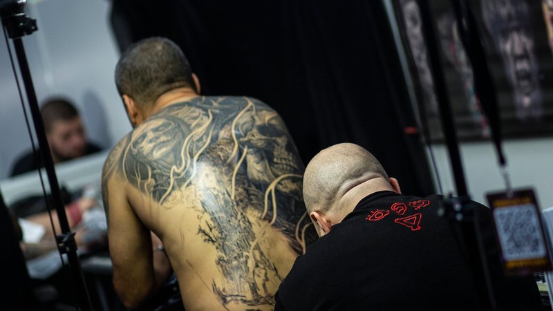 Tätowierer sticht einem Kunden eine Tätowierung am Rüclen | Bild: picture alliance / NurPhoto | Hristo Vladev Tätowierer sticht einem Kunden eine Tätowierung am Rüclen