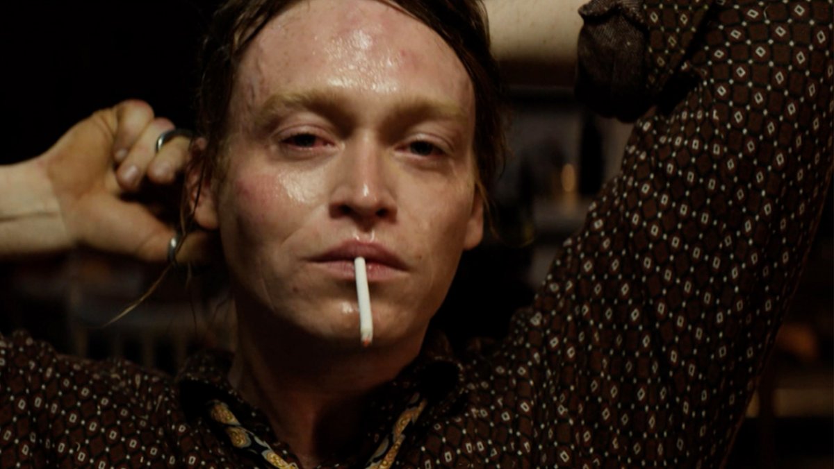 Ein ziemlich fertig aussehender Mann mit Zigarette im Mund und rotunterlaufenen Augen: Caleb Landry Jones als "Dogman" (Filmszene).
