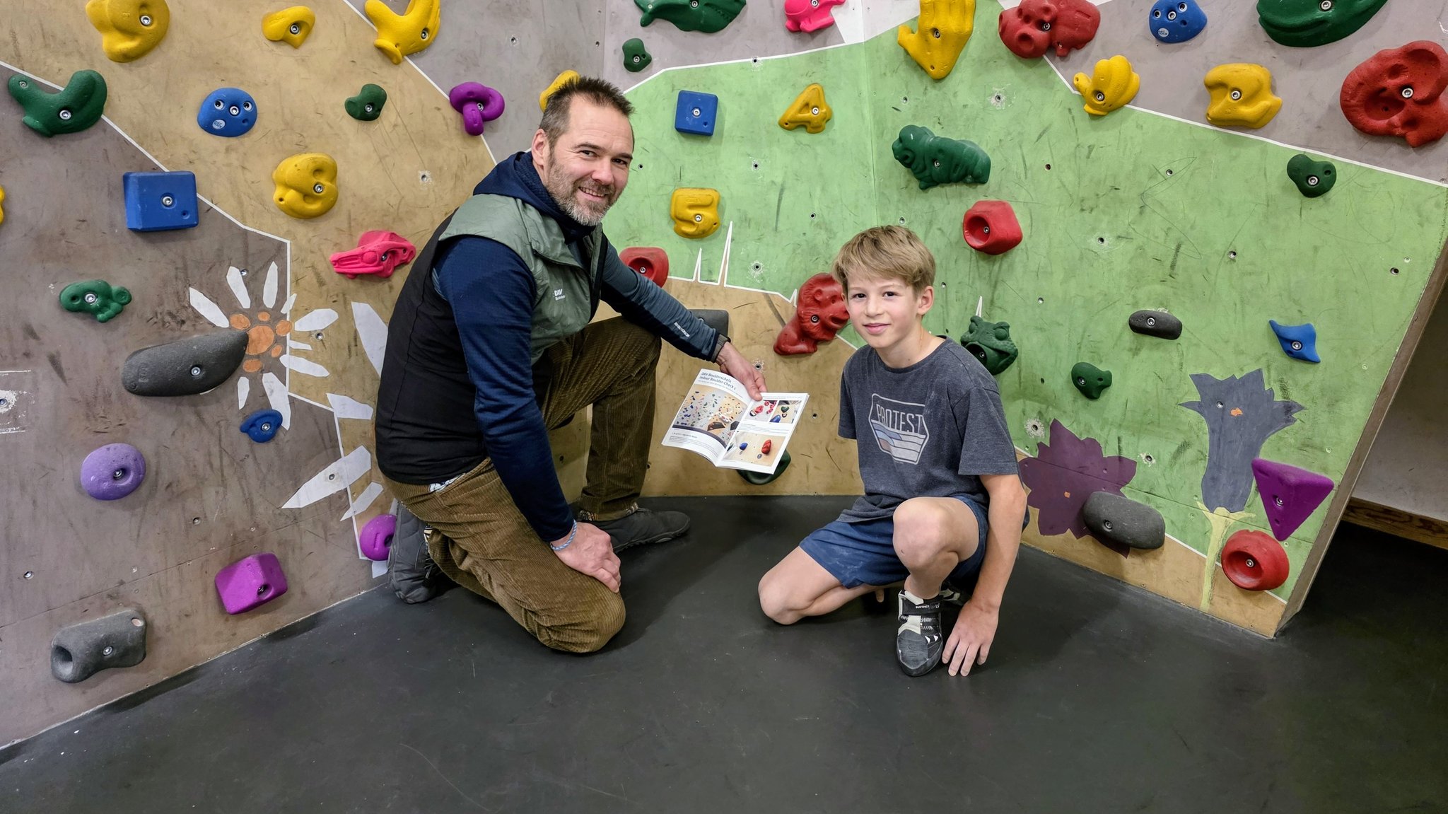 Torsten Silberhorn vom DAV Bundeslehrteam Sportklettern hat am Boulderschein mitgearbeitet und kniet mit Emil vor der Boulderwand. | Bild: BR / Ulrike Nikola Torsten Silberhorn vom DAV Bundeslehrteam Sportklettern hat am Boulderschein mitgearbeitet und kniet mit Emil vor der Boulderwand.