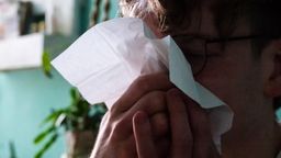 Ein Mann mit Taschentuch schnäuzt sich die Nase.  | Bild:picture alliance/dpa | Philip Dulian