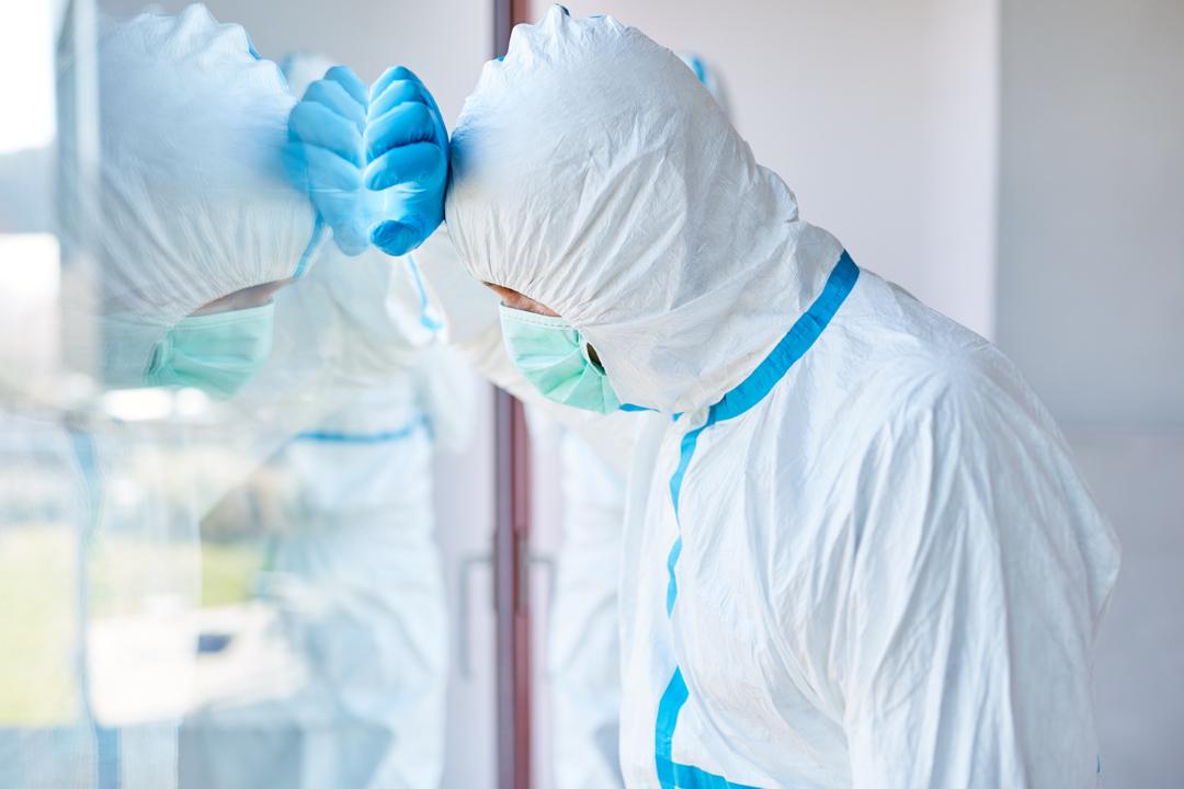 Ein erschöpfter Klinikarzt auf einer Intensivstation zur Zeit der Coronavirus-Pandemie. (Symbolbild) | Bild:stock.adobe.com/Robert Kneschke