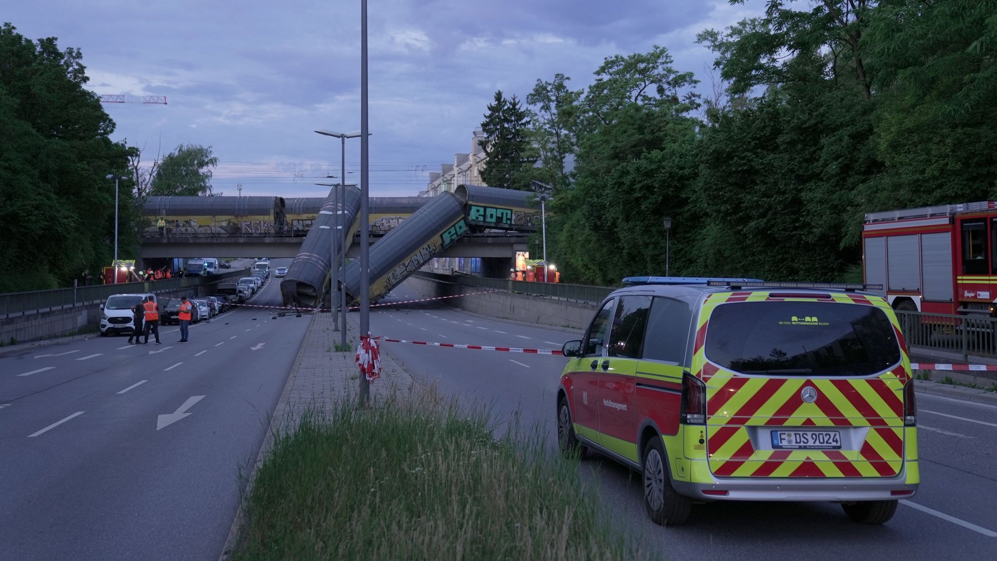 Zwei Waggons eines Güterzugs liegen auf einer Straße, nachdem sie von einer Brücke gestürzt sind. | Bild: dpa-Bildfunk/Ehsan Monajati Zwei Waggons eines Güterzugs liegen auf einer Straße, nachdem sie von einer Brücke gestürzt sind.