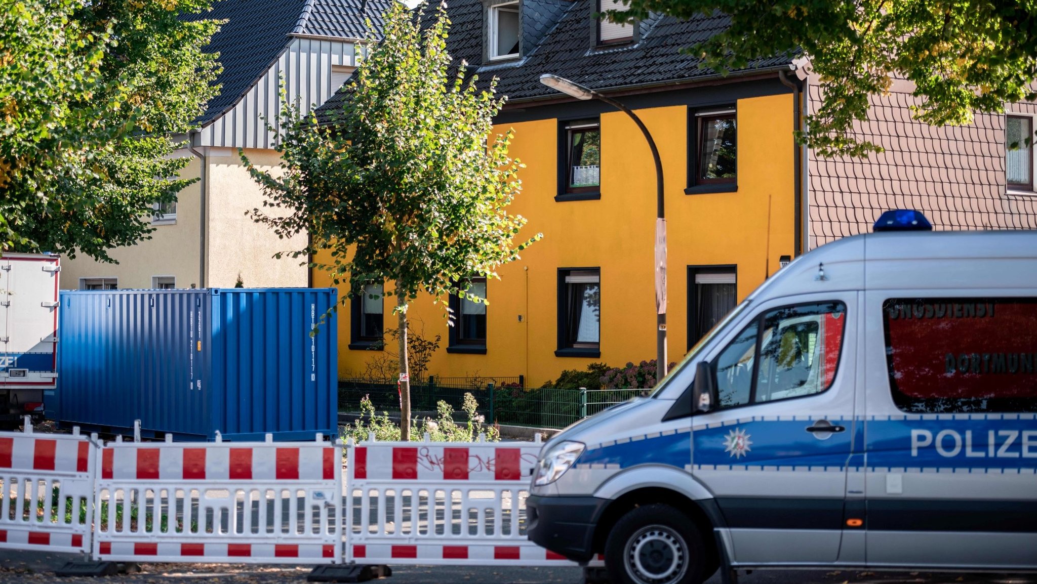 Ein Polizeibus steht in einem Wohngebiet