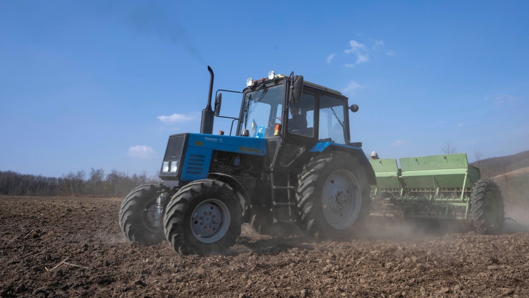 Traktor auf einem Weizenfeld im Westen der Ukraine.