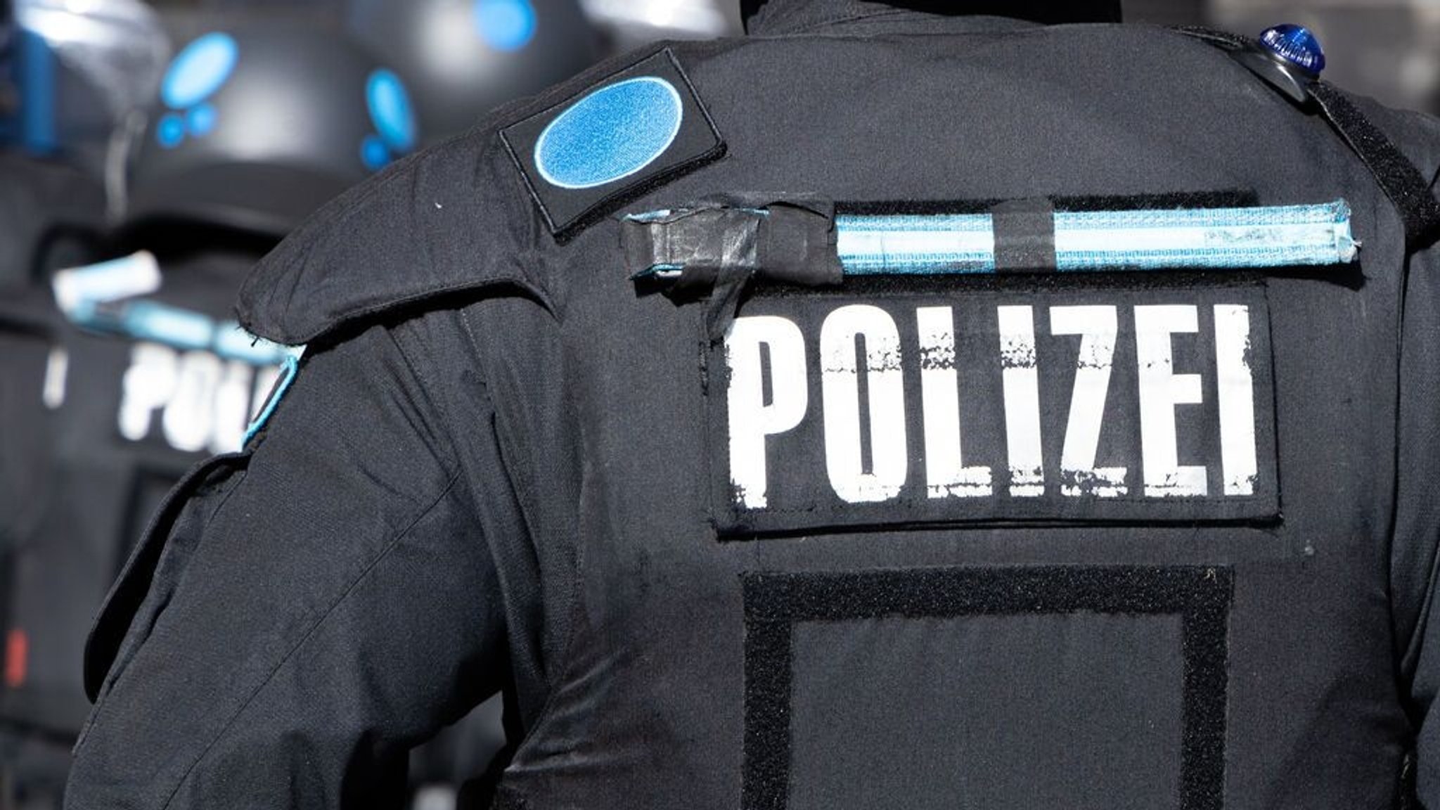 Ein Polizeibeamter des USK in Uniform von hinten.