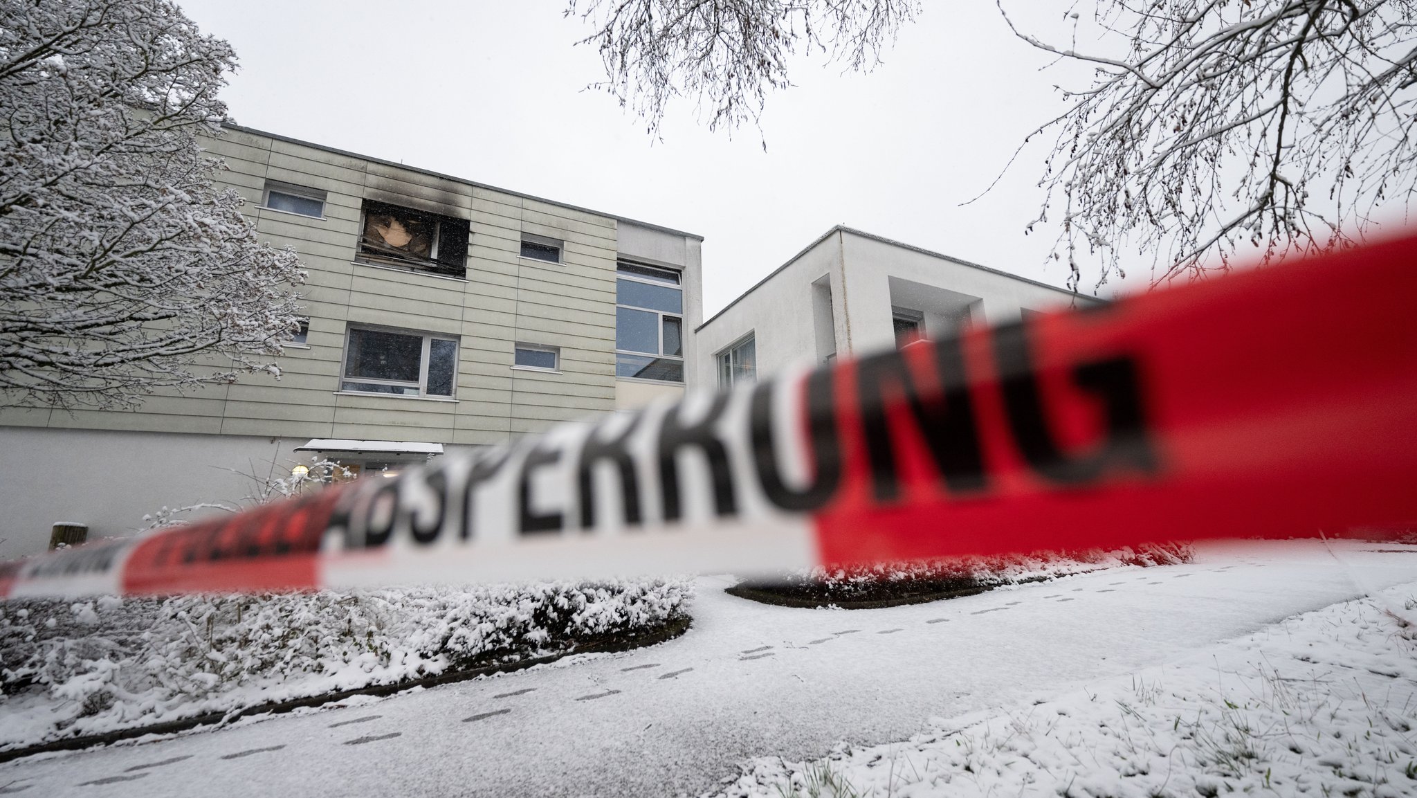 Polizeiabsperrband ist nach einem Brand in einer Pflegeeinrichtung um Teile des Gebäudes angebracht worden. Nach der Brandkatastrophe in einem Pflegeheim für psychisch kranke Menschen, bei der in Reutlingen drei Bewohner starben, ist die Ursache für das Feuer noch unklar.