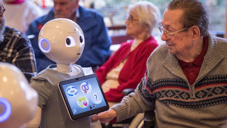 Symbolbild: Humanoider Roboter mit Bewohner eines Alten- und Pflegeheims