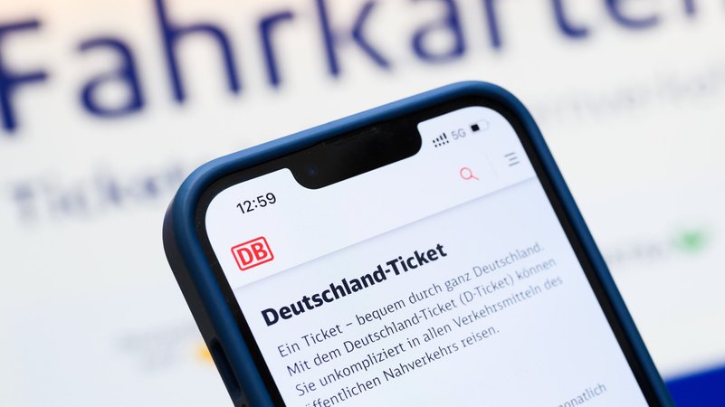 Eine Person hält am Hauptbahnhof ein Smartphone in der Hand, auf dessen Display eine Information zum Kauf des Deutschlandtickets zu sehen ist. | Bild: dpa-Bildfunk/Julian Stratenschulte Eine Person hält am Hauptbahnhof ein Smartphone in der Hand, auf dessen Display eine Information zum Kauf des Deutschlandtickets zu sehen ist.