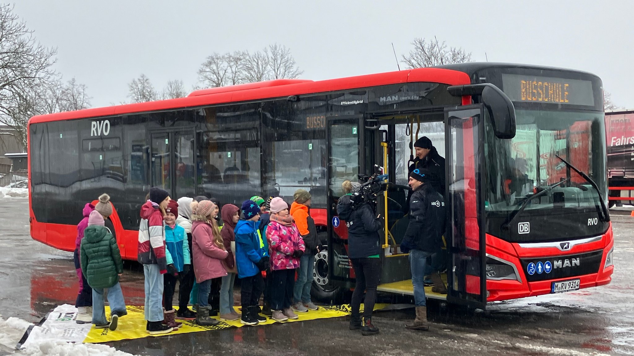 Die Kinder stehen im toten Winkel und können über die Spiegel im Bus nicht gesehen werden.